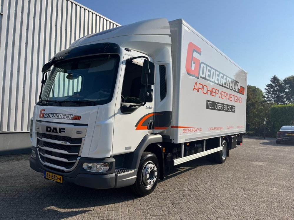 Een witte vrachtwagen van Goedegebuur met de opdruk archiefvernietiging, bedrijfsafval, datavernietiging en glasafval, geparkeerd op een verharde oprit